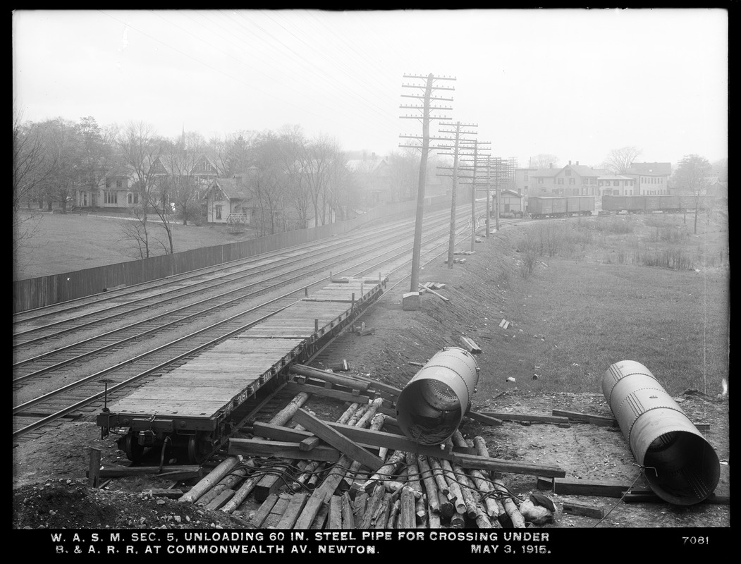 Distribution Department, Weston Aqueduct Supply Mains, Section 5, unloading 60-inch steel pipe for crossing under Boston & Albany Railroad at Commonwealth Avenue, Newton, Mass., May 3, 1915