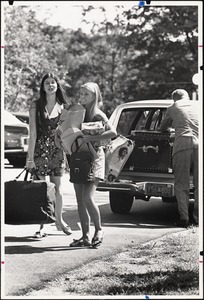 As freshman Julie Wilson arrives, Susan Altree '73, member of the Welcoming Committee, helps unload the car