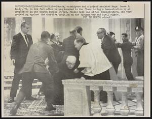 Ushers, worshipers and a priest assisted Msgr. James E. Kelly, 76, to his feet after he was knocked to the floor during a demonstration by 40 protesters in the church Sunday (9/22). Police held one of the demonstrators, who were protesting against the church's position on the Vietnam war and civil rights.