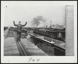 Rail Operations Resumed -- Railroad switchmen A.E. Smithwick (left), and J.W. Creel start clearing out a jam of long-idle freight cars in the Inman Yards here this morning. Freight movement through this southern rail center returned to near normal as 1,500 "sick" switchmen suddenly recovered and reported to work. In background at right, smoke rises from locomotives being fired up in preparation for their return to service.