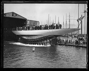 A crowd of people, mostly sailors, on top of yacht "Yankee" which is out of the water