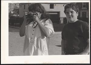 Two people, one with a camera, taking a photograph at Newtowne Court