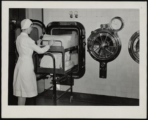 Faulkner Hospital operating room worker loading rectangular sterilizer in the autoclaves