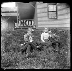 2 young couples lying in the grass in front of house