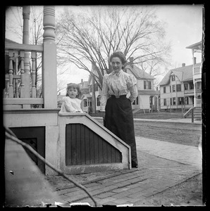 Mother & little girl outside with street & houses