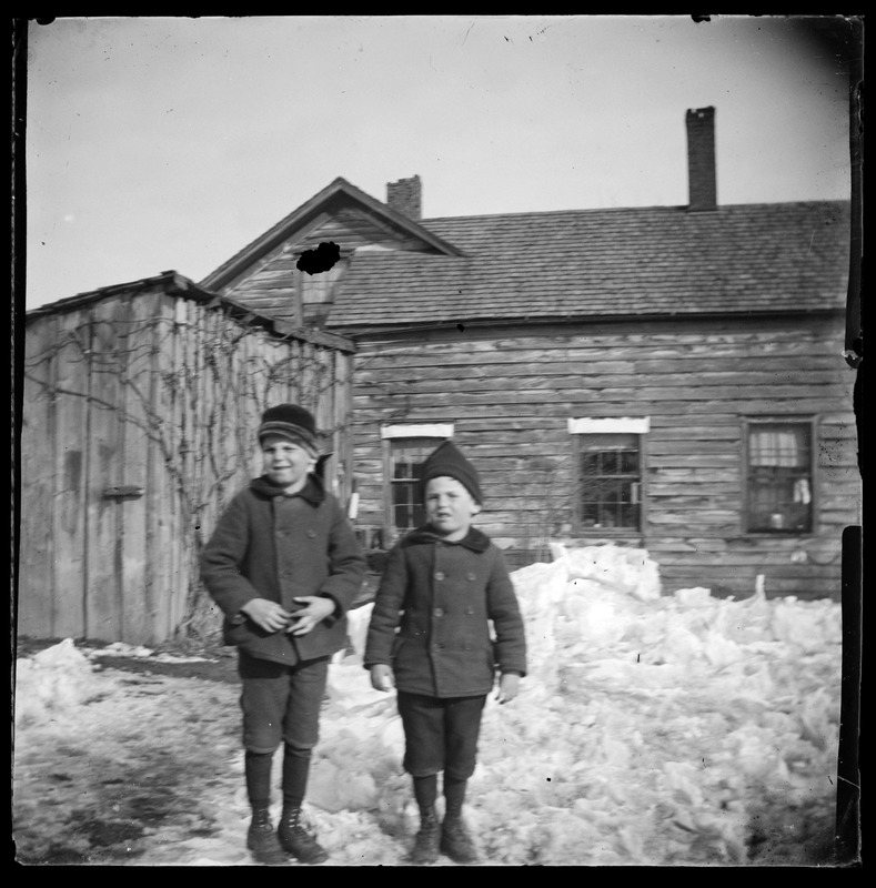 2 children outside of house in winter