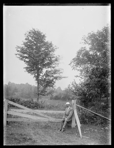 Augustus Martin at fence with pasture and tree behind