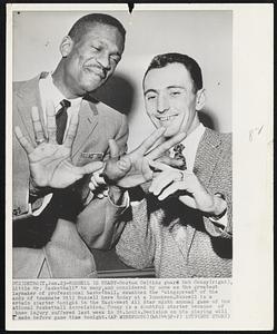 Russell Is Ready- Boston Celtics guard Bob Cousy (right), Little Mr. Basketball" to many, and considered by some as the greatest laymaker of professional basketball, examines the "wingspread" of the hands of teammate Bill Russell here today at a luncheon. Russell is a certain starter tonight in the East-West All Star ninth annual game of the National Basketball Association. Cousy is a doubtful starter because of knee injury suffered last week in St. Louis. Decision on his playing will be made before game time tonight.