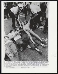 Police "Help" Demonstrators Out of Intersection -- Police begin to carry away a few of 133 antiwar demonstrators who were arrested after refusing to end their sit-in at one of Cincinnati's busiest intersections. More than 500 persons participated in the protest which followed a march from the University of Cincinnati. No violence was reported.