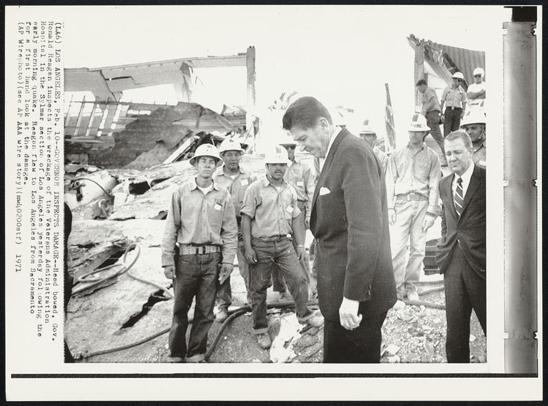 Governor Inspects Damage -- Head bowed, Gov. Ronald Reagan inspects the wreckage of the Veterans Administration Hospital in the Sylmar section of Los Angeles yesterday following the early morning quake. Reagan flew to Los Angeles from Sacramento for a first hand look at the damage.