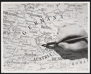 The Map Maker in a Changing World. A draftsman is here shown making preliminary corrections in Sudetenland on a wall map of Europe. Such correction maps are kept up-to-date from day to day and when official data is finally released by the government whose political boundaries are involved. The work of seriously correcting the map plates begin.