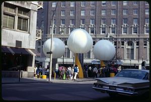 Large white balloons on a city street