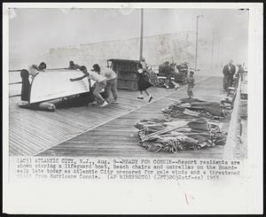 Ready For Connie -- Resort residents are shown storing a lifeguard boat, beach chairs and umbrellas on a Boardwalk late today at Atlantic City prepared for gale winds and a threatened walk late today as Atlantic City prepared for gale winds and a threatened visit from Hurricane Connie.