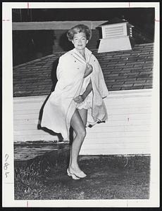 Mrs. Evelyn Higgins runs through the wind and rain early today as the Yachtsman Hotel in Hyannis was evacuated today. The hotel is headquarters the Kennedy press corps.
