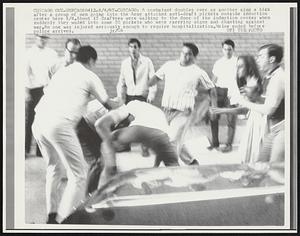 Chicago- A combatant doubles over as another aims a kick after a group of men going into the Army attacked anti-draft pickets outside induction center 8/4. About 15 draftees were walking to the door of the induction center when suddenly they waded into some 50 pickets who were carrying signs and chanting against war. No one was injured seriously enough to require hospitalization. Melee ended before police arrived.