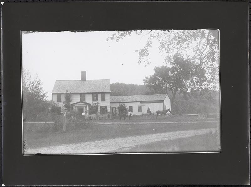 Center-entrance farm house, with persons posed in front