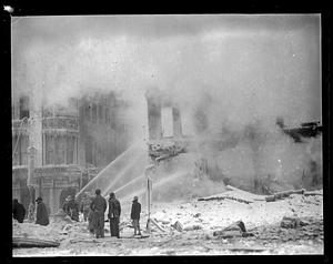 Firefighters using water hoses on the remains of a building, Lynn