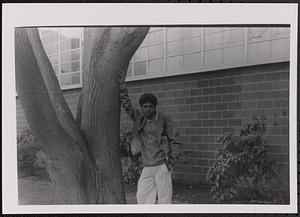 Boy leaning against a tree
