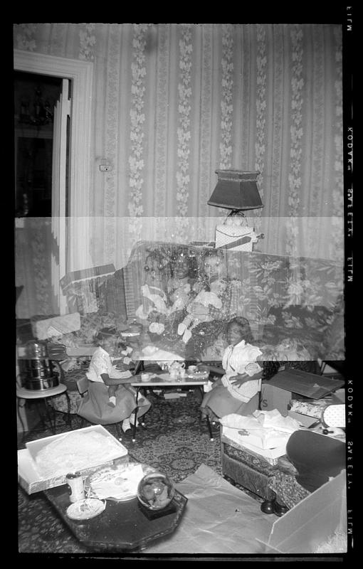 Four girls holding dolls. Christmas tree