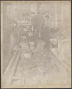 Three employees cleaning machines after the flood