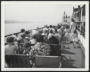 Scene on the upper deck of the Lloyd I. Seaman, a unique floating hospital which takes more than 900 mothers and their children for a free cruise around the waters of New York City every single day throughout summer. Operated by the St. John's Guild, a non-sectarian philanthropic organization, the trip is a combination joyride and health checkup. Free clinics are provided for the benefit of the mothers and their youngsters.