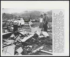 Tornado Damage-Al Moore stands with unidentified National Guardsman in wreckage of his service station destroyed Monday night by a tornado at the Cedar Grove community in Southeast Tennessee. Five persons were injured. The twister was one of a series which skipped across Tennessee, killing a boy at Parrostsville near the North Carolina line.