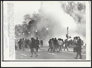 Using Tear Gas--Clouds of tear gas rise around demonstrators and police near the Justice Department in Washington tonight. A barrage of rocks and bottles from one segment of the demonstrators at Justice Department were hurled at police before tear gas was used.