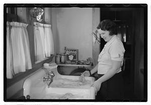 A woman at a sink full of laundry