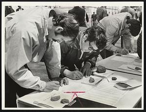 Cambodia Protesters sign letters to congressmen at Boston Common rally yesterday.