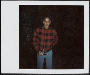 Young man in flannel shirt holding a Polaroid