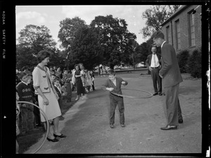 Jackie & JFK watch boy with hula hoop on visit to a school yard
