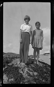 Two girls standing on a rock at the beach