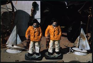 Front view of figurines of two sailboats and two fishermen