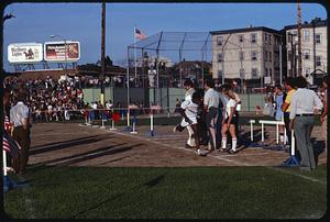 Runner crossing finish line at track event, Somerville