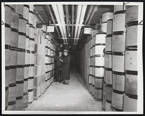 Workers inspect a Kansas City, Mo., plant of the U.S. Cold Storage Co., where cask upon cask of surplus cheese is stored. It is part of $350,000,000 worth of surplus dairy products in storage under the government's price support program.