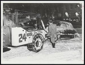 Scollay Sq - Tom Gallant of Roslindale called by police to tow away abandoned car on Cambridge St. near Hanover. Car there all might - section now cleared.