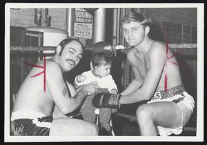 Somerville Boxers Paul Raymond (left) and John Coiley play with six-month-old Paul Jr. while training for their respective bouts Nov. 18 at Arena before closed circuit TV showing of Joe Frazier-Bob Foster world heavyweight title fight.