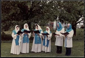 Singing group in costumes, back of Lawrence Library