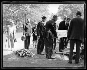 Pallbearers laying coffin down to be buried, Richard E. Byrd in the background