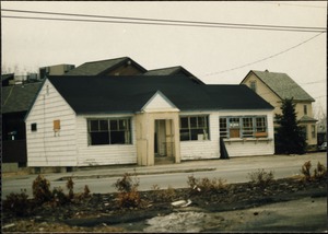 View of a wooden building with some boarded-up windows