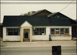 Wooden building with two windows boarded-up