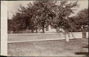 Unidentified house with tree and fence in the foreground