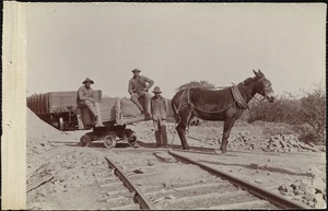 Three men and a horse pulling a mining car