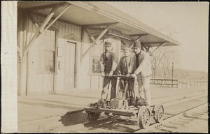 Workers of the Mass Central Railroad posed in front of the West Boylston Station at the lower Common, driving a hand car