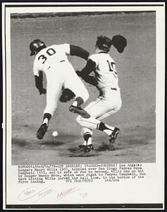 (Padres-Dodgers) Los Angeles Dodgers Maury Wills (30), topples over San Diego Padres Dave Campbell (10), and is safe on run to second. Wills ran on hit by Dodger Manny Mota, which went right to Padres Campbell, but hard hitting Wills jarred the ball lose, in the bottom of the first inning.