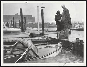 To Late to Bail--Forlorn couple stand in wind and rain at Boston Marina in Squantum and watch their boat ship water. Wind-shipped waves at times prevented boat-owners from reaching end of dock.