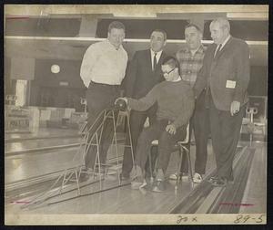 L-R (Standing) -George Sellew Jr., an owner of Fairway Sports World where Tournament of Champions is held. John Buccheri of Acton, creator of bowling aid in photo. Sumner Shlager of Framingham (Director of recreation of SMARC, South Middlesex Assn. of Retarded Children. Leo Madden of Wellesley, Director of Charles River Workshop. (Afflicted youngster is Jock Casten of Natick