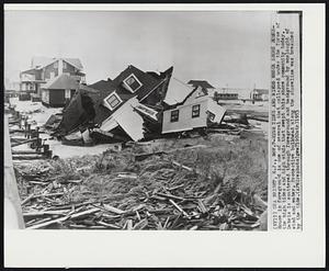 Sea Bright, N.J. - High Tides And Winds Wreck Shore Homes - House in foreground is one of several that collapsed under the force of the high tides and high winds that swept this shore community today. Debris is scattered through foreground and background by onslaught of wind and water. Protective bulkhead along the shoreline was breached by the tide.