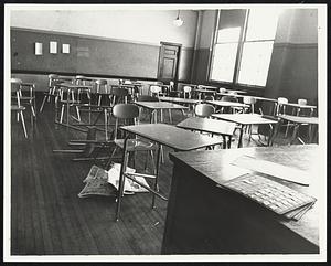 Overturned desks + chair in empty classroom at Boston English High School