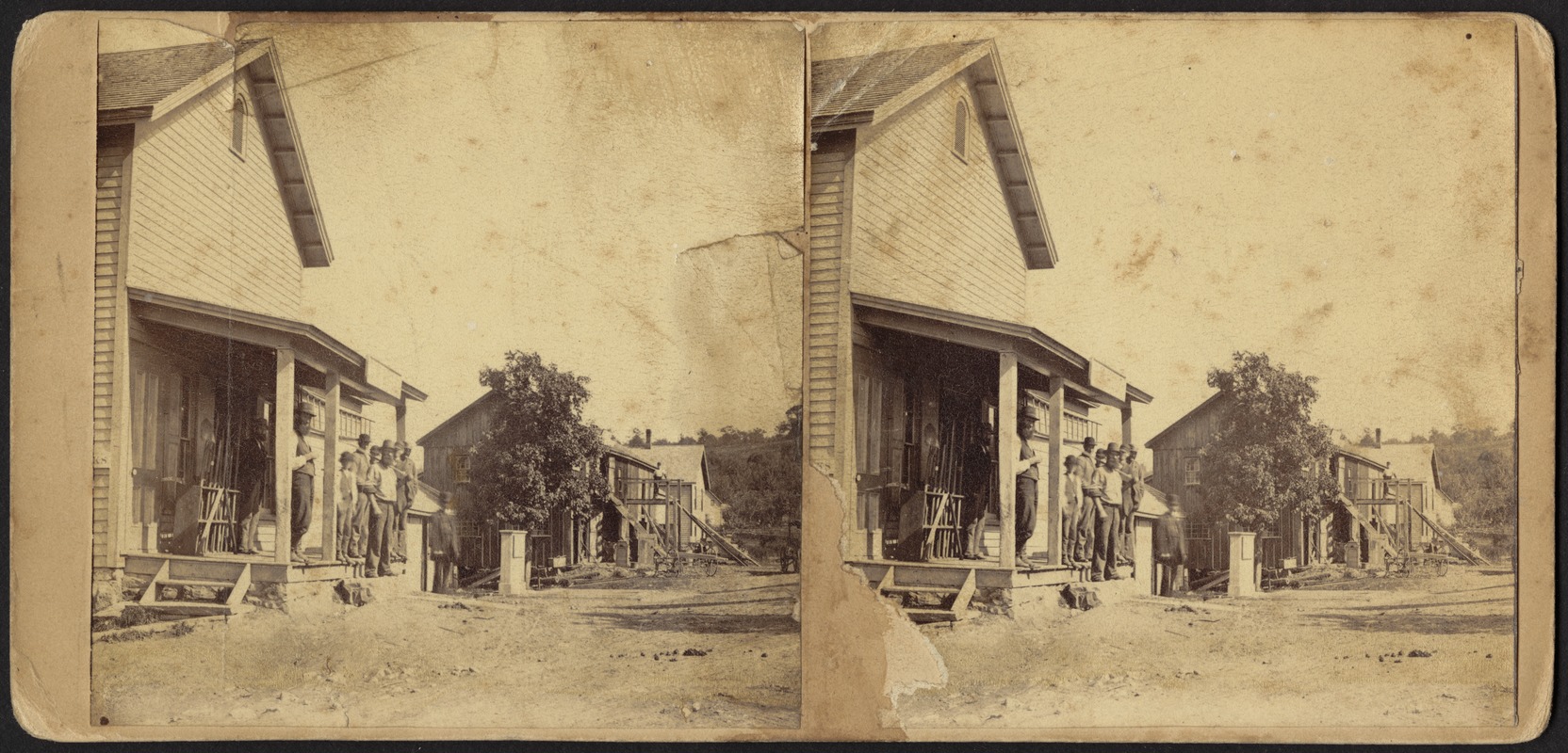 Unidentified men standing on porch in rural town